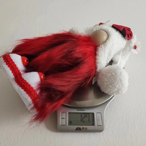Mesure du poids de la peluche gnome scarabée rouge affichant environ 127,1 grammes