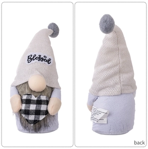 Macro detail of gnome plush featuring a 'Blessed' knit hat and buffalo plaid heart