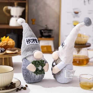 Detail of grey and white Swedish Gnomes holding wreaths in a cozy coffee shop setting