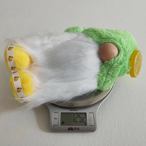 Detail of summer lemon gnome plush showing a 125.2g weight on a kitchen scale