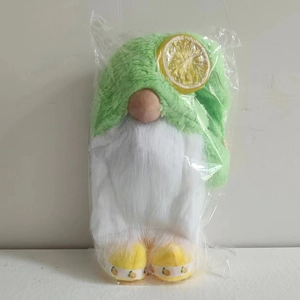 Detail view of summer lemon gnome plush toy in clear plastic protective packaging