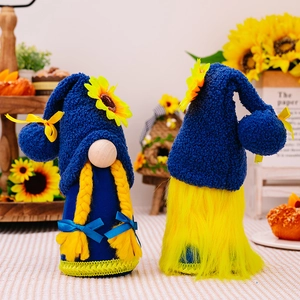 Set of two standing sunflower gnomes with blue hats and yellow braids on a cozy table