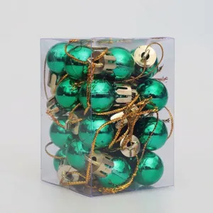 Detalle de bolas de Navidad verdes de 2cm con tapas doradas en caja transparente