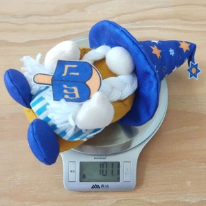 Gnome de Hanoucca en peluche avec toupie pesé sur une balance numérique à 101,1g