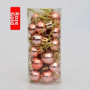 Close-up of 2cm rose gold mini Christmas balls in a cylindrical gift tube packaging