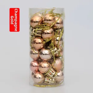 Close-up of champagne gold mini Christmas tree ball ornaments in a clear cylinder box