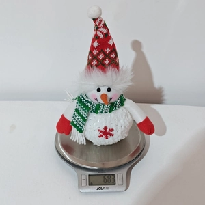 Detail shot of a plush Christmas snowman on a digital scale showing weight of 68.3g