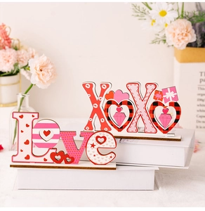Détail des signes LOVE et XOXO en bois pour la Saint-Valentin avec motifs de cœur et carreaux