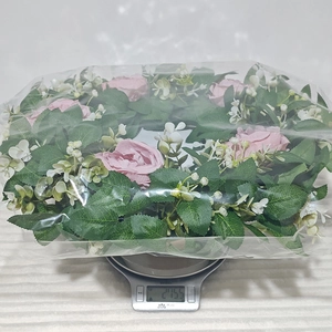 Rosafarbener künstlicher Rosenkranz mit einem Gewicht von 275,5 g auf einer Waage angezeigt
