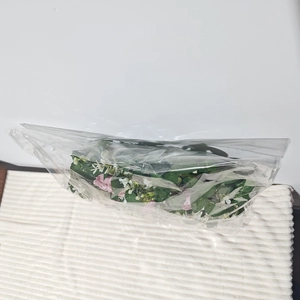 Detailansicht von rosa und weißen Kunstblumen in transparenter Kunststoffverpackung