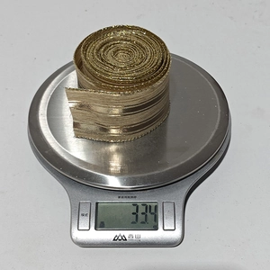 Detailed view of gold metallic linen ribbon roll weighing 33.4g for Christmas decor