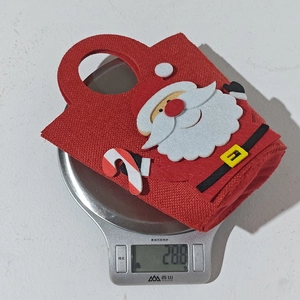 Detailed view of lightweight Santa Claus gift bag on a digital scale weighing 28.8g