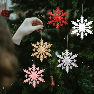 Décorations de flocons de neige scintillants en cinq couleurs sur un sapin de Noël festif