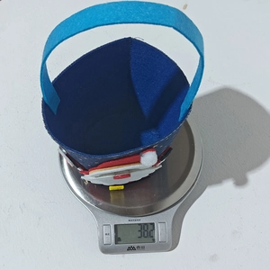 Detail shot showing the lightweight 38.2g blue felt Christmas gift bag on a scale