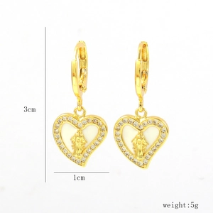 Detail view of heart-shaped gold-plated Maria earrings with crystals and white enamel