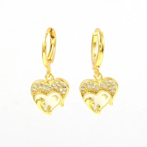 Macro view of gold heart earrings with white enamel and maternal figure relief