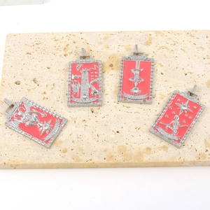 Set of four retro tarot pendants with red enamel and crystals on stone background