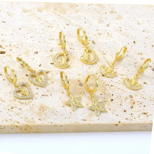 Macro detail of 18k gold plated earring set with zircon religious virgin mary pendants