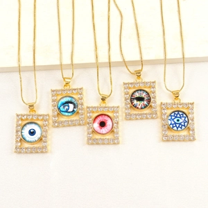 Macro detail of five square 18k gold plated evil eye pendants with micro-paved zircons