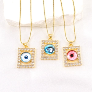 Detail of square gold pendants featuring micro-set zircon and colorful evil eye designs