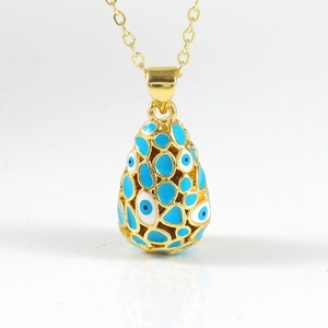 Détail macro du collier pendentif goutte en or 18K avec motif œil bleu en émail