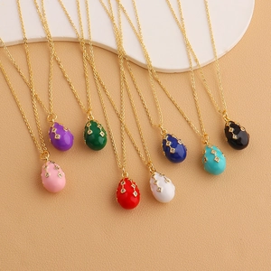 Detailed macro view of colorful enamel Easter egg pendants with gold plating and zircons