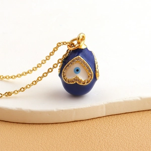Detailed close-up of blue enamel egg pendant with heart zircon and evil eye motif