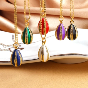 Detail of colorful Faberge style egg pendants with zircons on gold necklaces