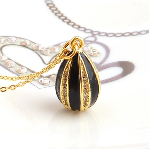 Macro view of a gold-plated vintage egg pendant with black enamel and white zircon inlay