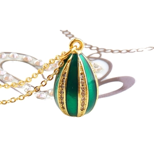 Elegant green enamel egg pendant necklace with gold accents and cubic zirconia stones
