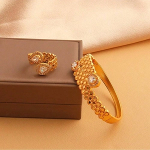 Vue détaillée du bracelet jonc doré évidé et de la bague sertie de zircons poire