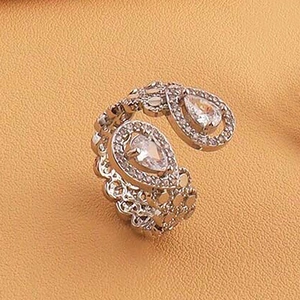 Détail macro d'une bague vintage en argent avec zircons en goutte sur cuir orange