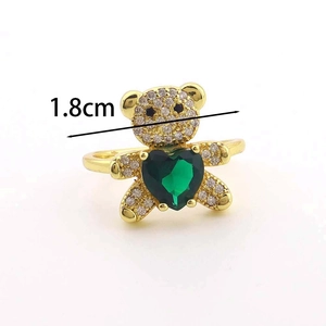 Détail d'une bague ours dorée de 1,8 cm avec zircons et pierre en forme de cœur vert