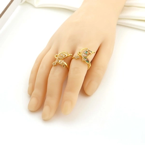 Détail de bagues papillon dorées avec zircons multicolores portées sur une main de mannequin