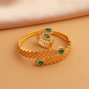 Détail de l'ensemble bague et bracelet avec pierres vertes sur fond de soie douce