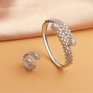 Détail de l'ensemble bracelet manchette évidé et bague argentée avec pierres blanches
