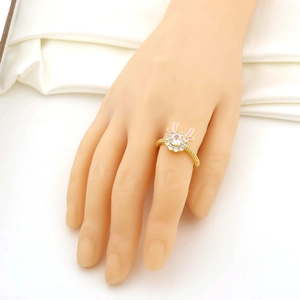 Détail d'une bague fleur dorée sertie de zircons avec petites oreilles roses