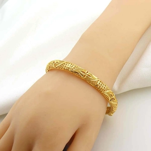 Lussuoso bracciale placcato oro con motivo floreale traforato da donna su bianco