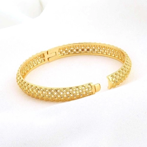 Detail van de 24K vergulde filigraan armband met kristallen op een witte stoffen basis
