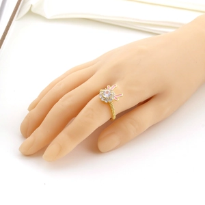 Détail d'une bague lapin dorée avec pierre ronde et oreilles en émail rose