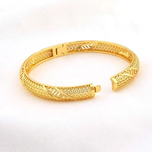 Detail van het opengewerkte rooster en Grieks patroon op de 24K vergulde armband