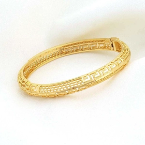 Dettaglio macro del bracciale placcato oro 24K con design greco traforato