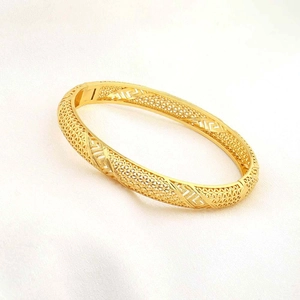 Detailopname van 24K vergulde armband met opengewerkt gaas en Grieks sleutelpatroon