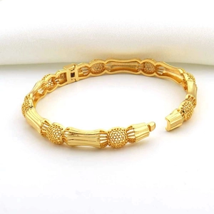 Detail van 18K vergulde open armband met holle geometrische kralen en bamboe-stijl buisjes
