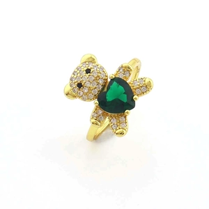Vue détaillée d'une bague ours dorée avec zircons blancs et une pierre cœur verte