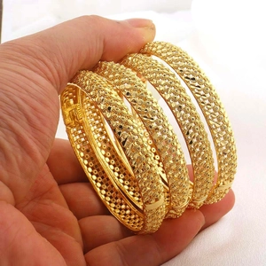 Detail van vier 24K vergulde armbanden met ingewikkelde bloemige filigraanpatronen