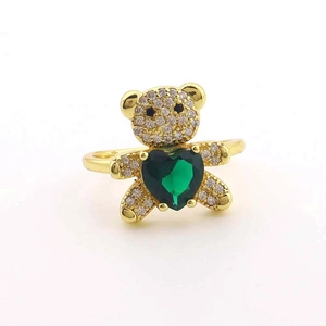 Détail d'une bague ours en peluche dorée avec émeraude en cœur et pierres de zircon blanc