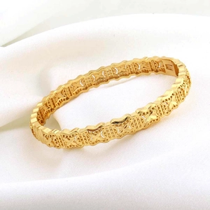 Detail van 24K vergulde armband met opengewerkte sterpatronen en een handige kliksluiting