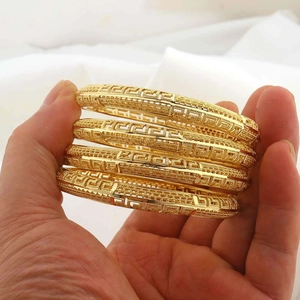 Set di quattro bracciali rigidi placcati oro 24K con motivi a chiave greca traforati