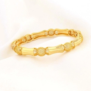 Detail van de 18K vergulde armband met holle bollen en bamboe-achtige textuur
